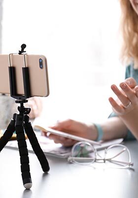 Female blogger recording video at table